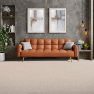 Modern living room with a burnt orange sofa, light beige textured carpet, and industrial-style decor, highlighting the neutral-toned flooring.